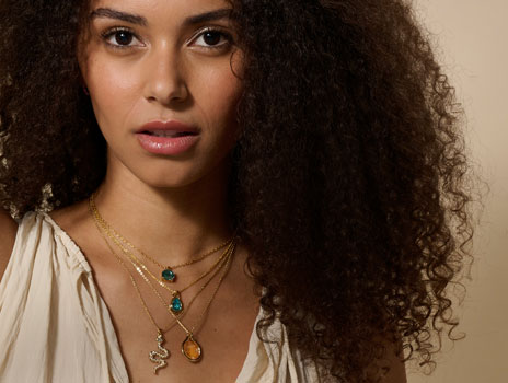 Woman wearing colorful crystal and gold necklaces