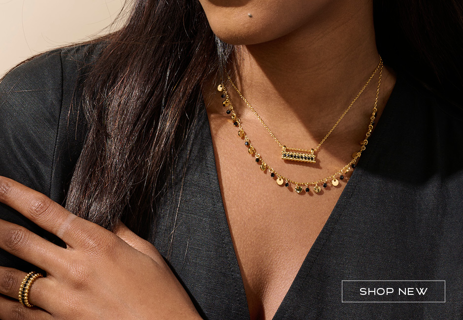 Model wearing gold and black jewelry